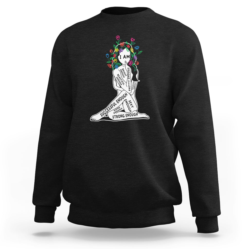 Black crewneck sweatshirt with colorful “I AM” portrait graphic and motivational text
