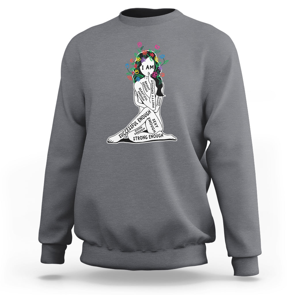 Gray crewneck sweatshirt with colorful “I AM” portrait graphic and motivational text