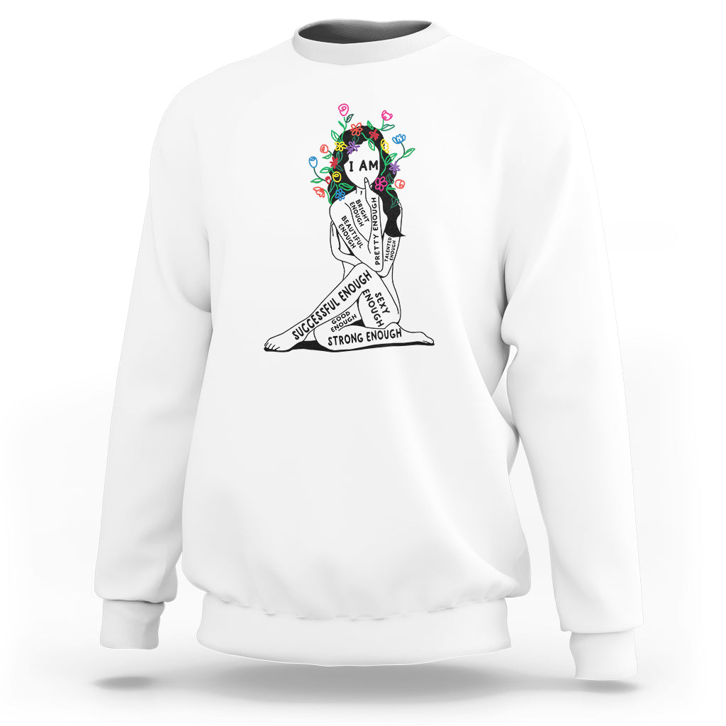 White crewneck sweatshirt with colorful “I AM” portrait graphic and motivational text