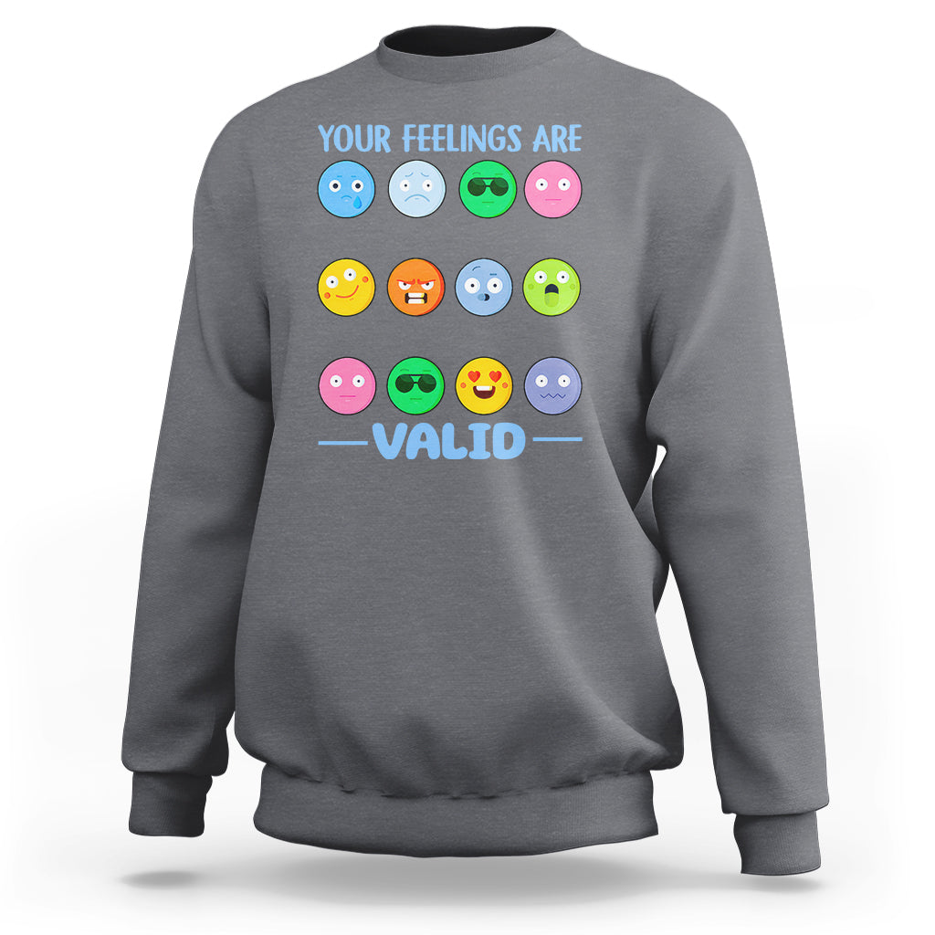 Charcoal gray sweatshirt with “YOUR FEELINGS ARE VALID” text and colorful emotion-face graphics.