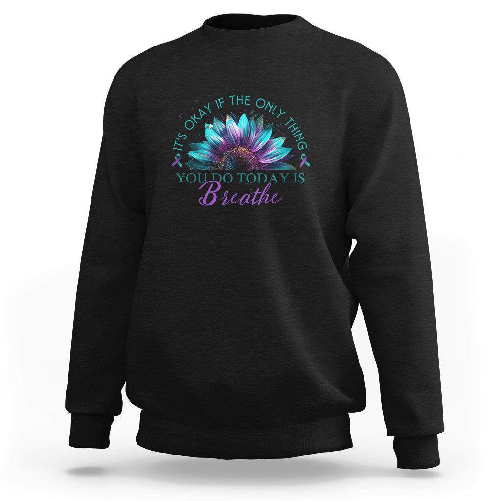 Black crewneck sweatshirt with turquoise flower graphic and “Breathe” text