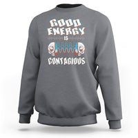Charcoal gray crewneck sweatshirt with “Good Energy Is Contagious” skull graphic on chest