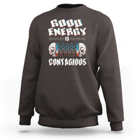 Dark chocolate crewneck sweatshirt with “Good Energy Is Contagious” skull graphic on chest