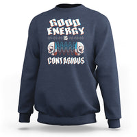 Navy crewneck sweatshirt with “Good Energy Is Contagious” skull graphic on chest