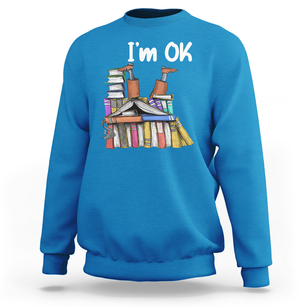 Blue crewneck sweatshirt with "I'm OK" book stack graphic on front.