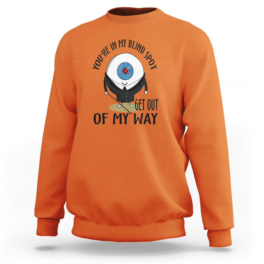 Orange crewneck sweatshirt with blind spot character graphic and “GET OUT OF MY WAY” print