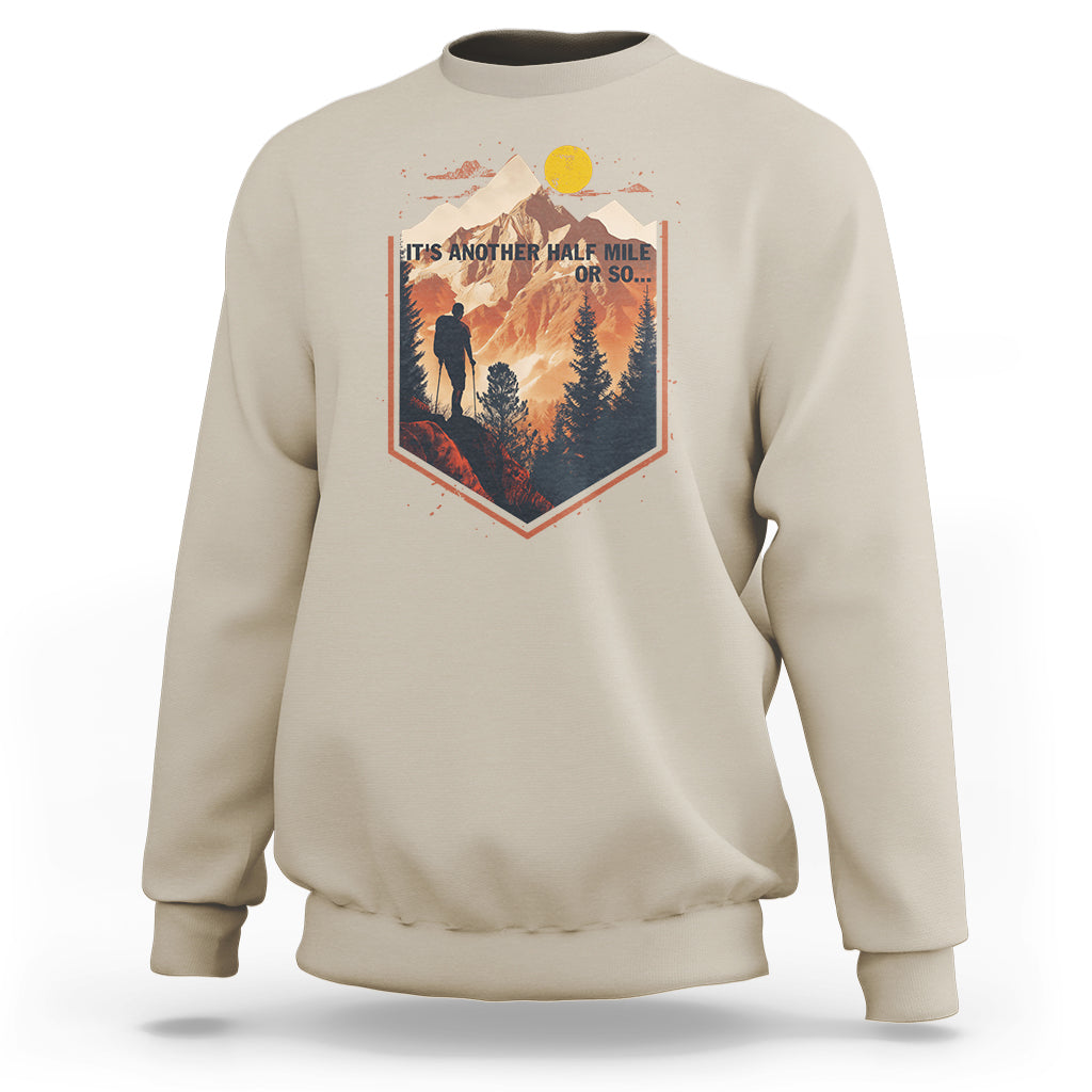 Sand tan crewneck sweatshirt with hiking scene graphic on chest