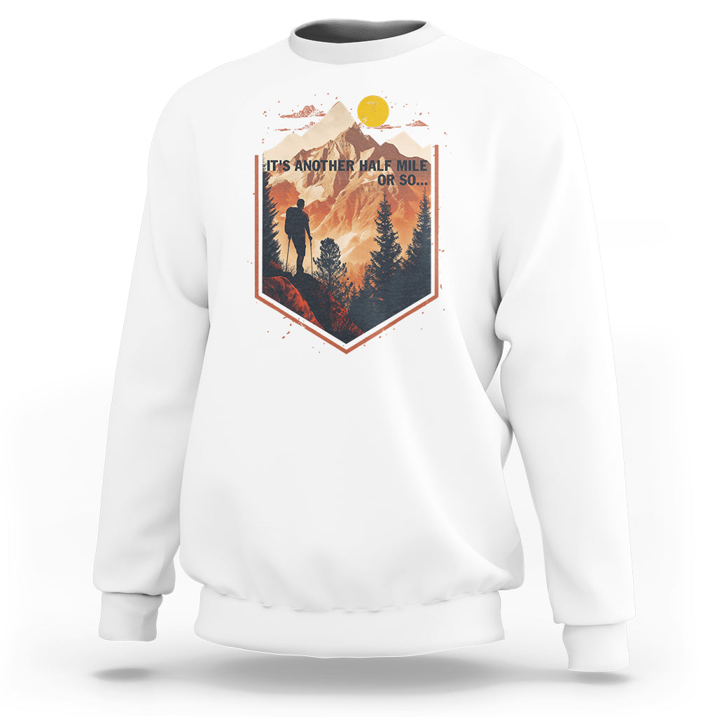 White crewneck sweatshirt with hiking scene graphic on chest