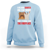 Light blue Christmas sweatshirt with cat by fireplace and holiday text graphic