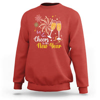 Red crewneck sweatshirt with “Cheers to the New Year” fireworks and champagne glasses print