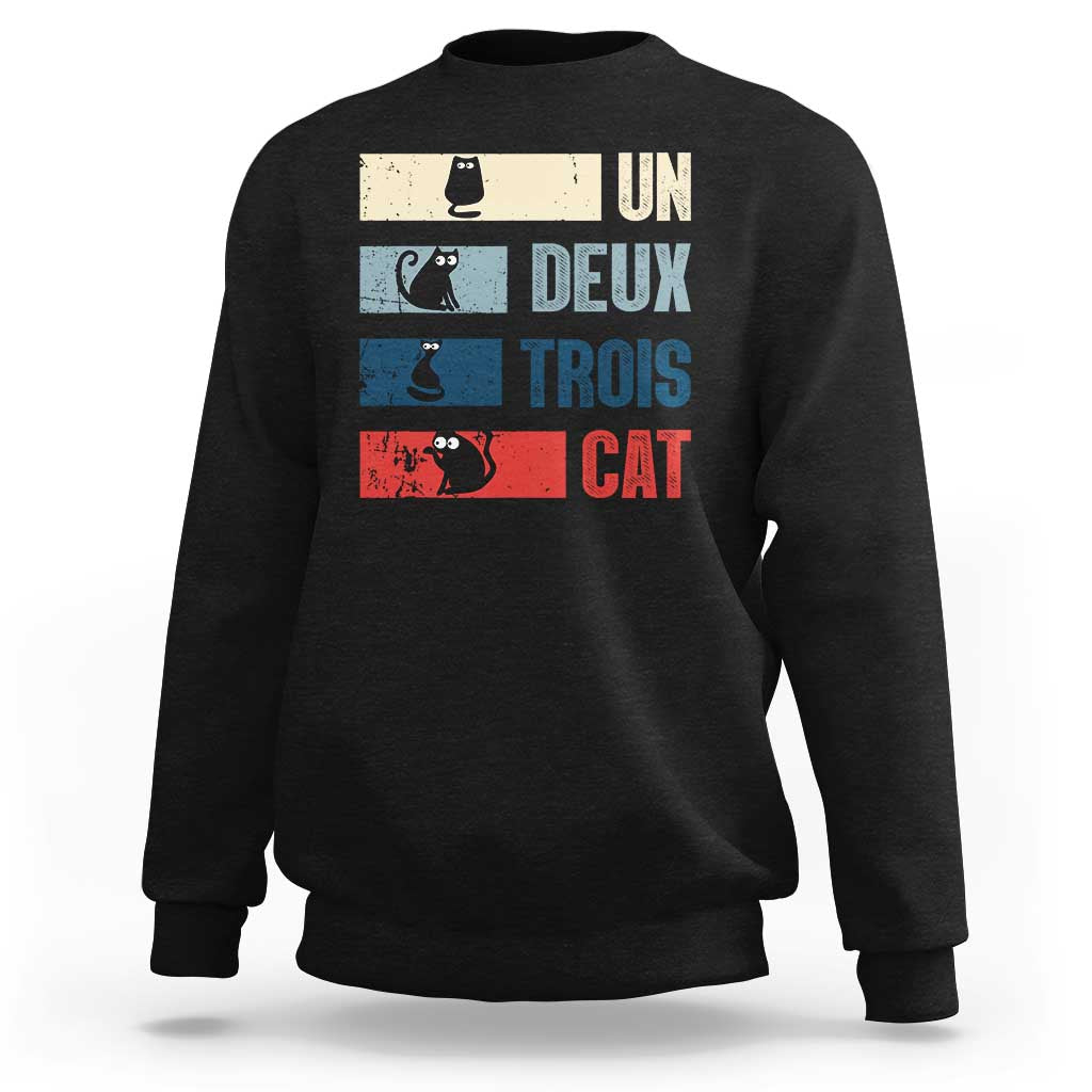 Black sweatshirt with “UN DEUX TROIS CAT” graphic and striped cat blocks on front
