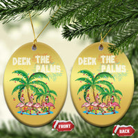 Two gold oval Christmas ornaments with “Deck the Palms” flamingo palm artwork