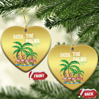 Two gold heart-shaped ornaments with “Deck the Palms” flamingo palm artwork