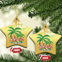 Two gold star-shaped “Deck the Palms” ornaments with flamingo palm scene