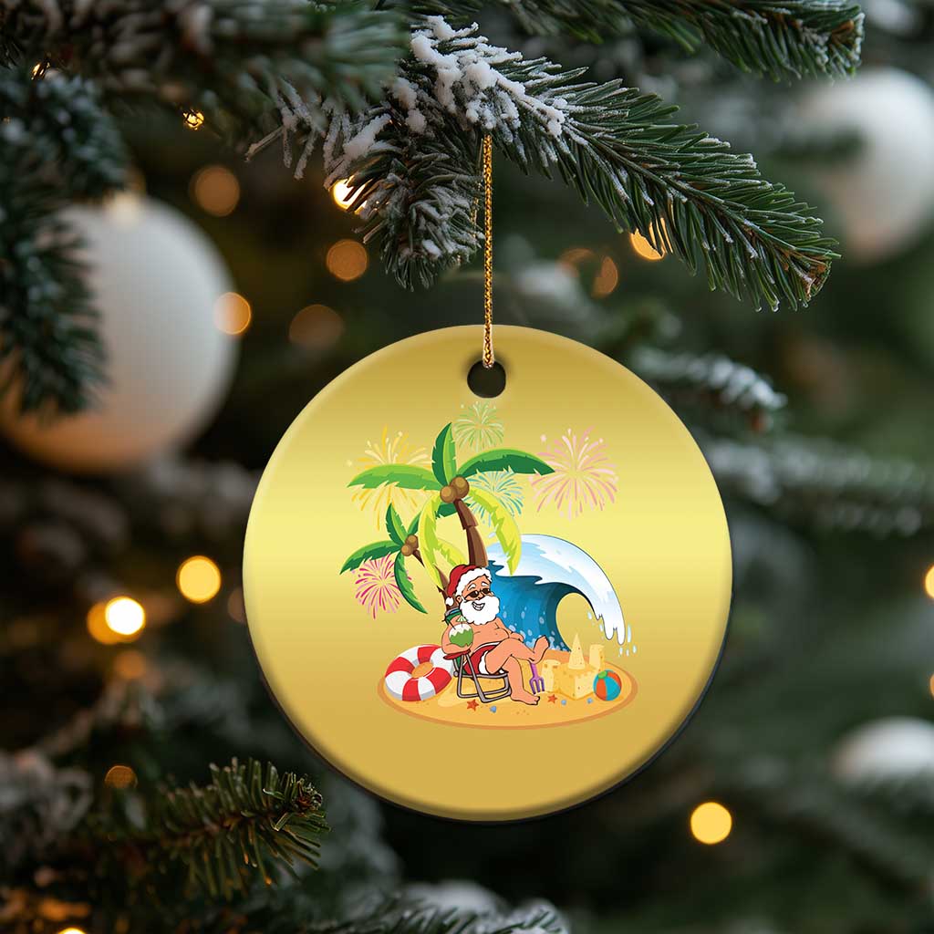 Gold round ornament with Santa relaxing on beach under palm trees, hanging on tree.