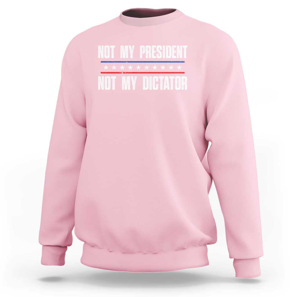 Light pink crewneck sweatshirt with “Not My President / Not My Dictator” front graphic
