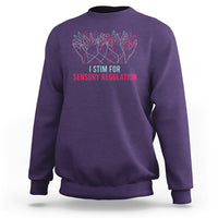 Purple crewneck sweatshirt with colorful hand graphic and “I STIM FOR SENSORY REGULATION”.