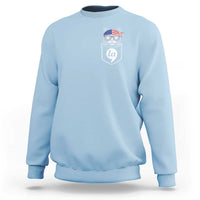Light blue crewneck sweatshirt with chest graphic of a cat wearing patriotic hat badge