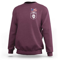 Maroon crewneck sweatshirt with chest graphic of a cat wearing patriotic hat badge