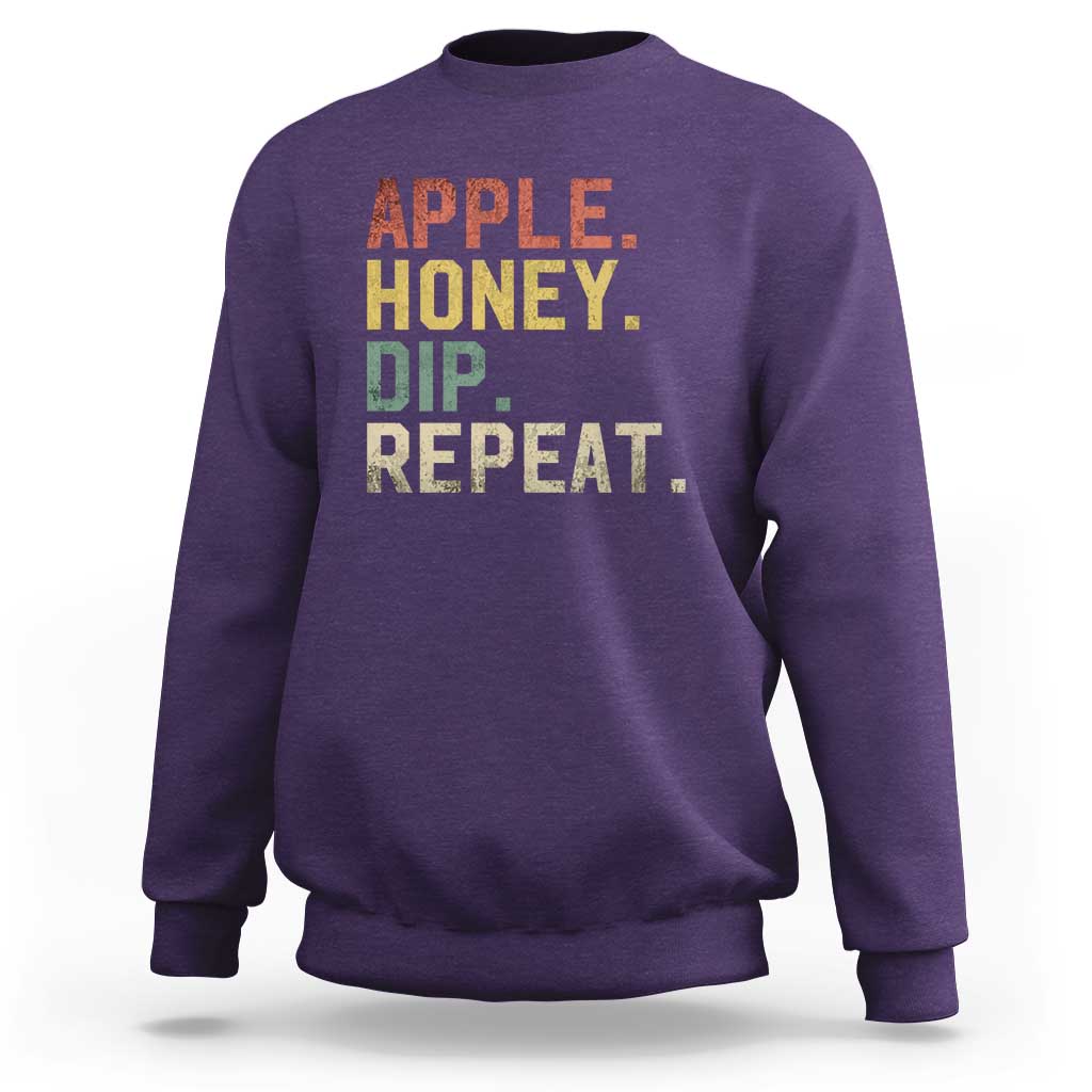 Rosh Hashanah sweatshirt in purple with “APPLE HONEY DIP REPEAT” graphic