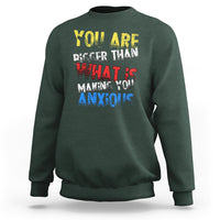 Dark forest green crewneck sweatshirt with colorful front slogan graphic