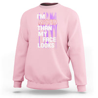 Light pink crewneck sweatshirt with front graphic text: “I’m nicer than my face looks”