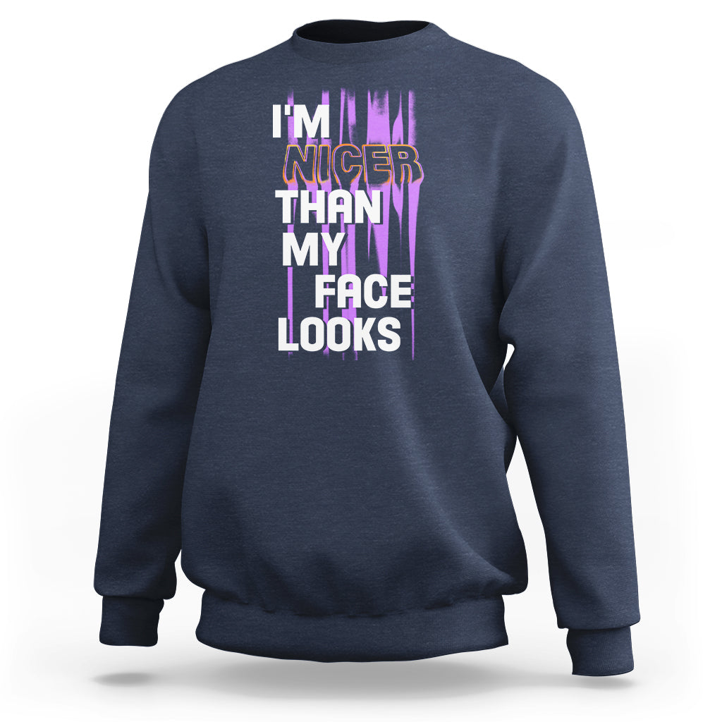 Navy crewneck sweatshirt with front graphic text: “I’m nicer than my face looks”