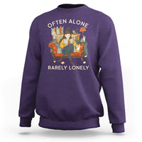 Purple crewneck sweatshirt with graphic text 'OFTEN ALONE' and 'RARELY LONELY'.
