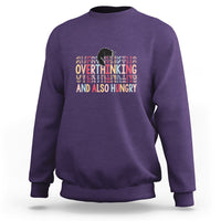 Purple crewneck sweatshirt with cute cat and “Overthinking And Also Hungry” graphic