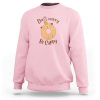 Light pink capybara lover sweatshirt with “Don’t worry, Be Cappy” graphic on chest