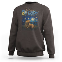 Dark brown crewneck sweatshirt with colorful capybara night graphic on the front
