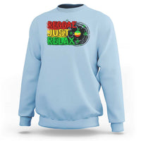 Light blue crewneck sweatshirt with colorful 'Reggae Just Relax' graphic and leaf print