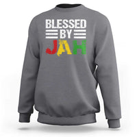 Charcoal gray crewneck sweatshirt with 'Blessed By Jah' reggae-style JAH graphic on front.