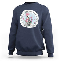 Navy crewneck sweatshirt with circular skeleton and rose floral graphic on chest.