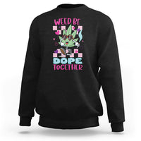 Black crewneck sweatshirt with colorful “WEED BE DOPE TOGETHER” cannabis graphic