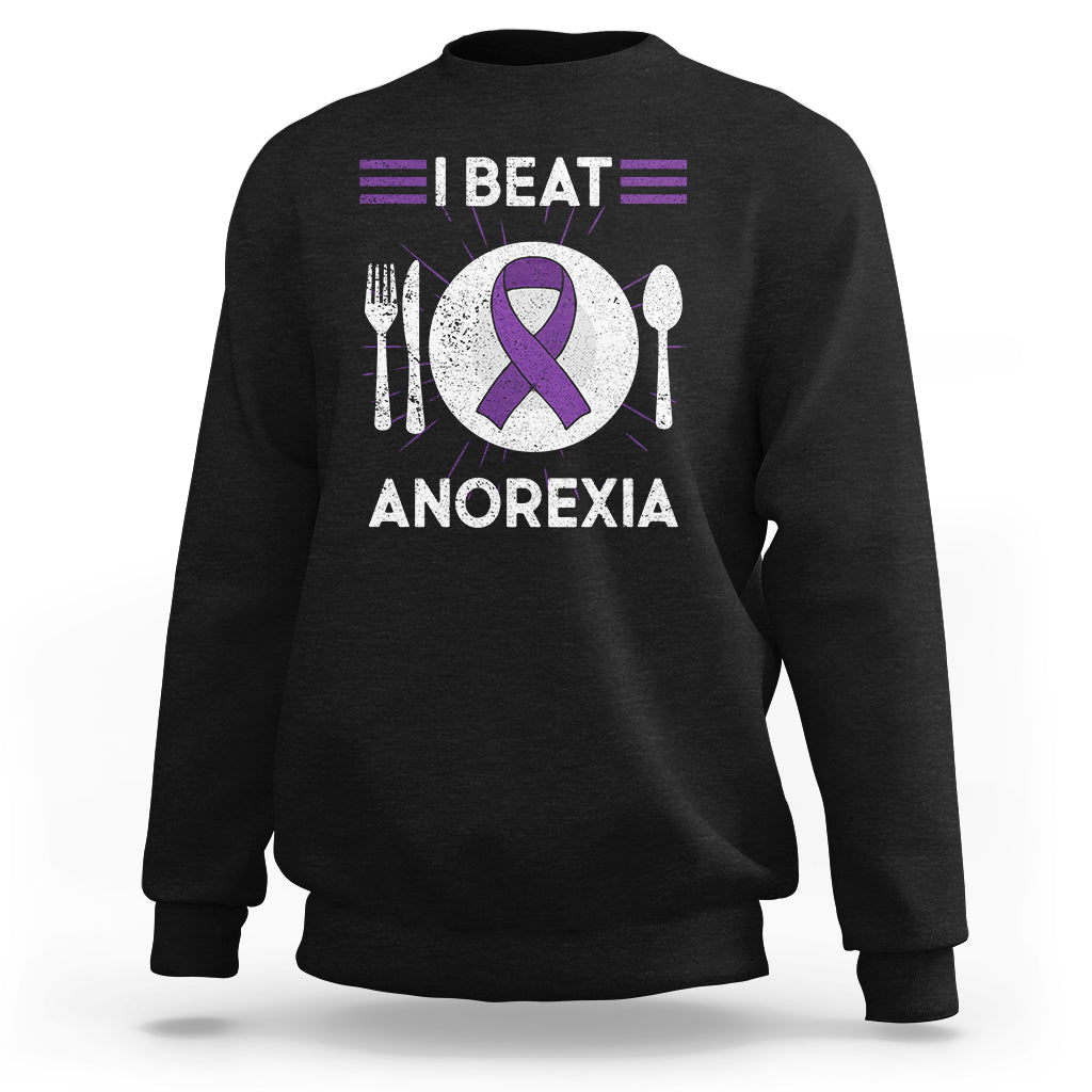 Black sweatshirt with purple ribbon “I BEAT ANOREXIA” graphic and fork/spoon symbols
