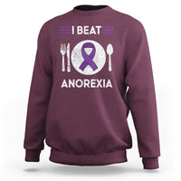 Maroon sweatshirt with purple ribbon “I BEAT ANOREXIA” graphic and fork/spoon symbols