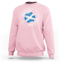 Light pink crewneck sweatshirt with circular Scotland logo graphic on the chest