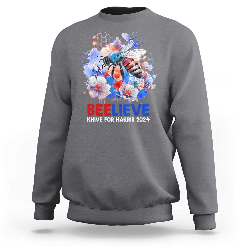 Gray sweatshirt with bee-and-flowers graphic and 'BELIEVE' text on front.
