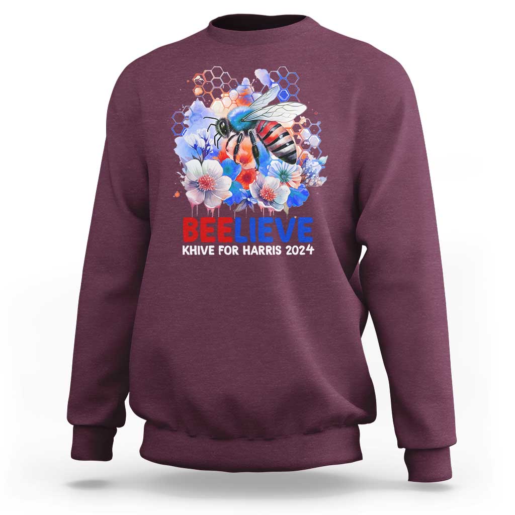 Maroon sweatshirt with bee-and-flowers graphic and 'BELIEVE' text on front.