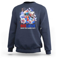 Navy sweatshirt with bee-and-flowers graphic and 'BELIEVE' text on front.