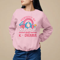 Light pink sweatshirt with large "POWERED BY K-POP" and "K-DRAMA" graphic