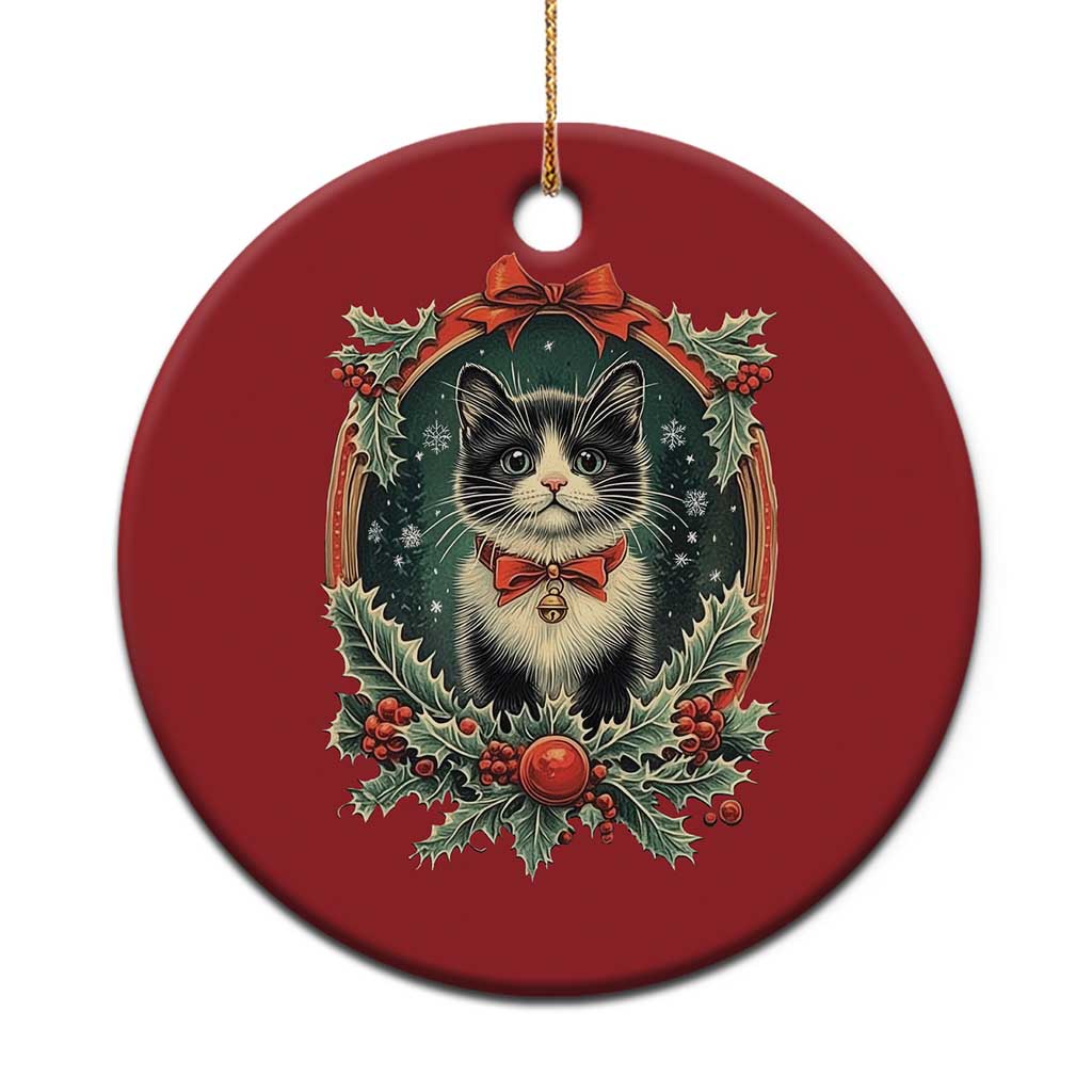 Red round Christmas cat ornament with holly wreath and ribbon bow design