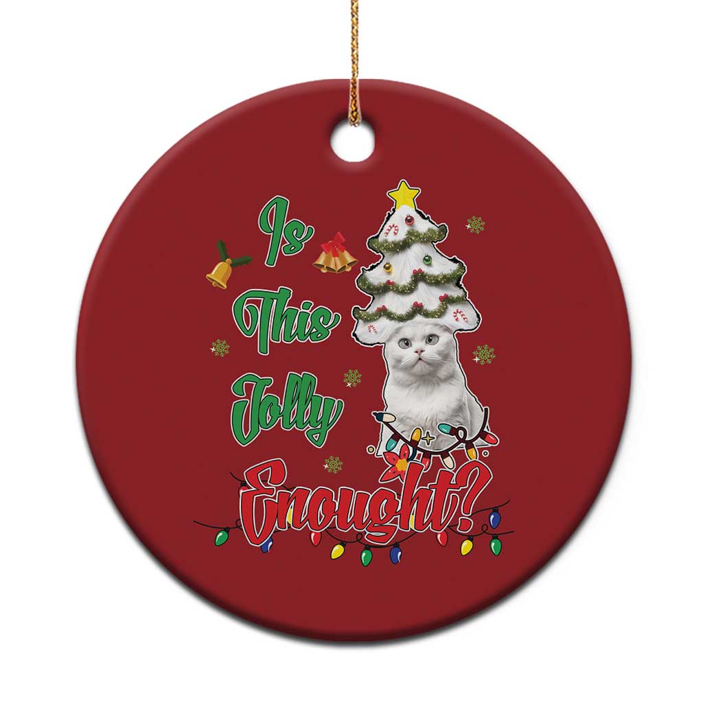 Red round Christmas ornament with a white cat, decorated tree, and holiday text.