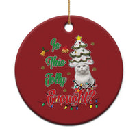Red round Christmas ornament with a white cat, decorated tree, and holiday text.