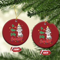 Two red round cat Christmas ornaments hanging on a tree, front and back views.