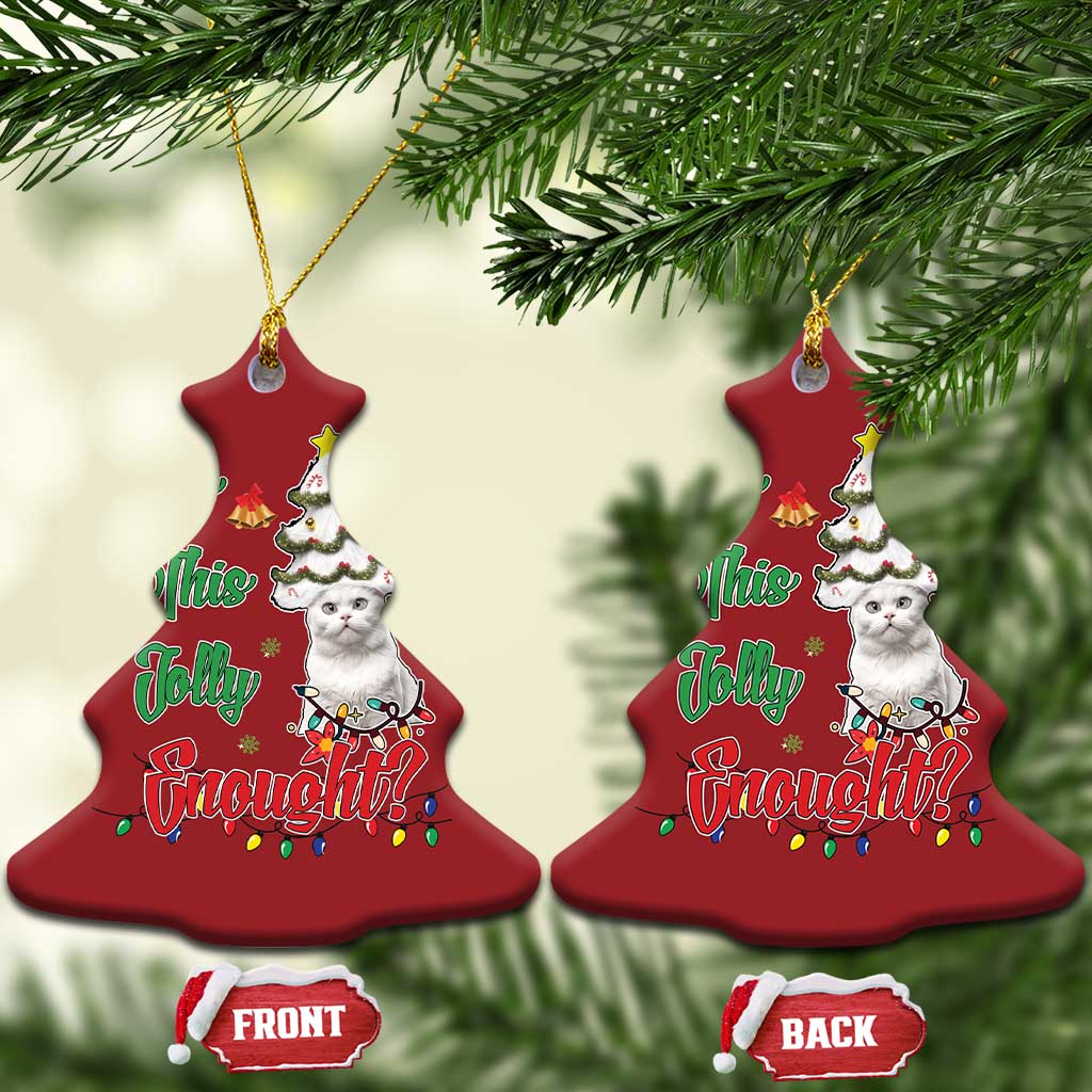 Red bell-shaped cat Christmas ornaments hanging on evergreen branches with festive design.