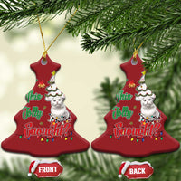 Red bell-shaped cat Christmas ornaments hanging on evergreen branches with festive design.