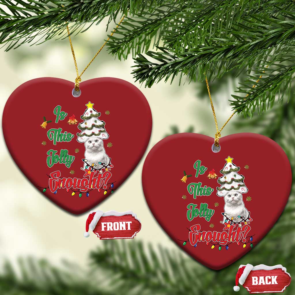 Two red heart-shaped cat Christmas ornaments hanging on evergreen branches.