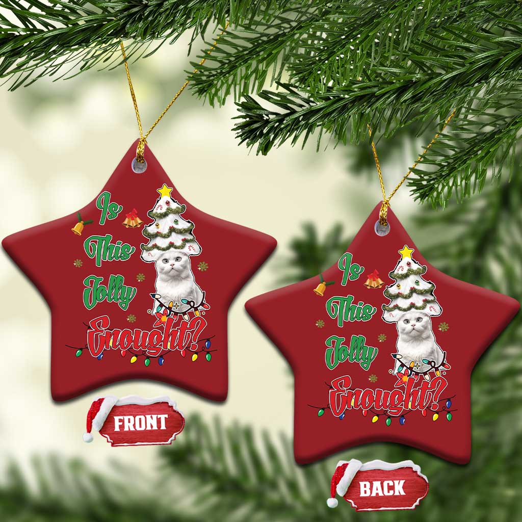Two red star-shaped cat Christmas ornaments hanging on evergreen branches.
